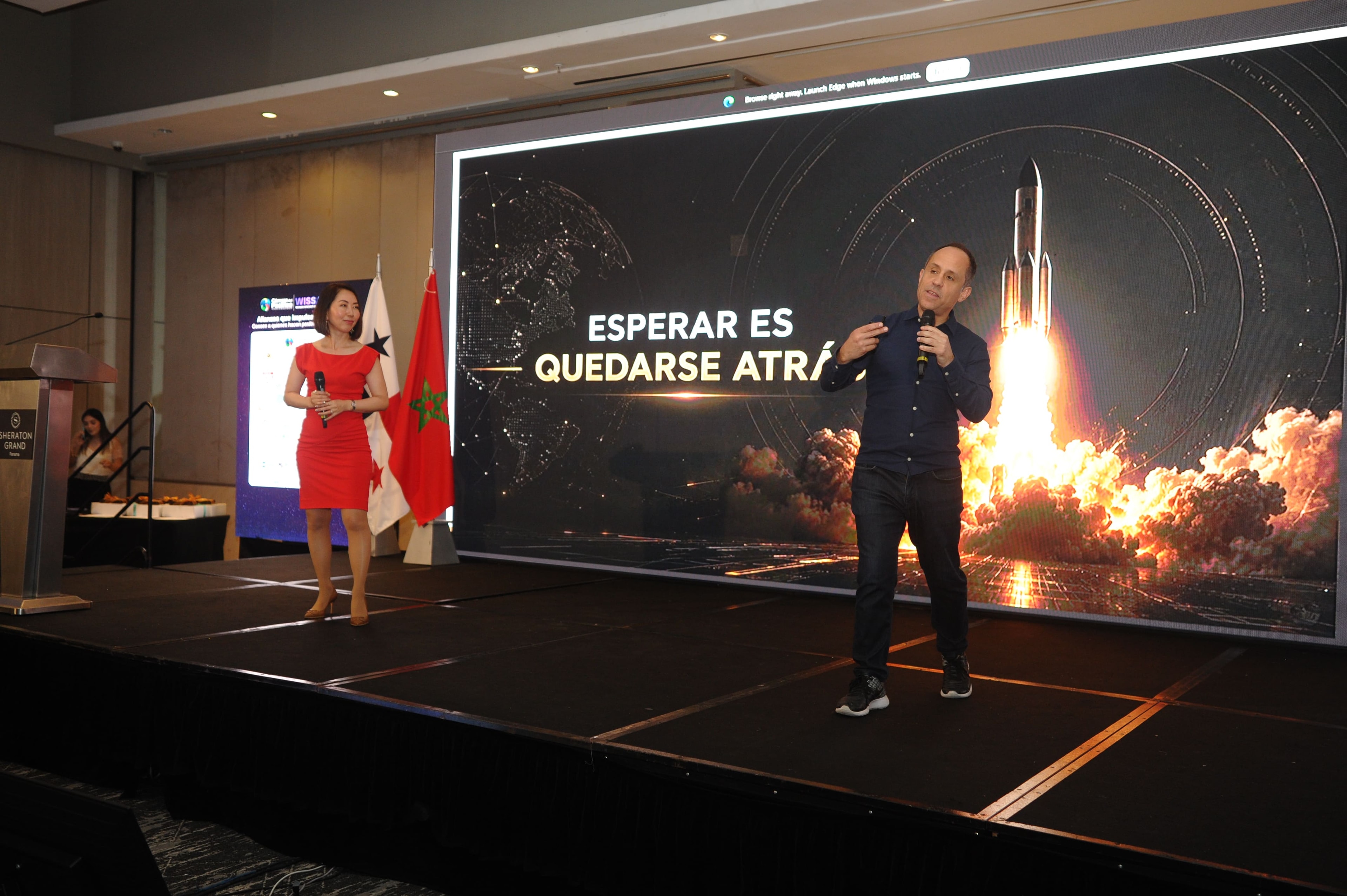 Pablo Menichetti en el escenario con pantalla "Esperar es quedarse atrás" — Foro Empresarial WISS Latam 2026